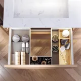 Baderomsinspirasjon med baderomsmøbler i grønn spesialfarge med sider i naturlig eik, elegante riller, stilfull benkeplate med romantisk oval bordstående servant, vakkert ovalt speil, gir sammen med blomstrete tapet et yndefullt, vintage retro uttrykk.