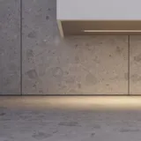 Elegant og moderne baderomsinspirasjon med mørke marmorerte vegger, runde opplyste speil med svart ramme, vegghengt servantskap med dobbeltvask og en romslig dusjniche