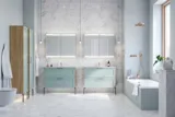 Stor baderomsinspirasjon med lys blå baderomsmøbler med lys tretopper, elegante speilskap, minimalistiske svarte ben og håndtak, dobbelt baderomssett og store hvite marmorfliser gir et klassisk, moderne og symmetrisk uttrykk