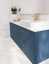Baderomsinspirasjon med baderomsmøbler i moderne blå farge, elegant bordstående vask og stort firkantet speil med lys, hvite fiskebensfliser gir et stilfullt og klassisk uttrykk