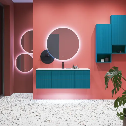 Stort baderomsinspirasjon med baderomsmøbler i blå spesialfarge med rifler, tynn elegant servant samt vakre runde speil, røde vegger og terrazzogulv skaper stor kontrast til møblene og gir et stilig og urbant uttrykk.