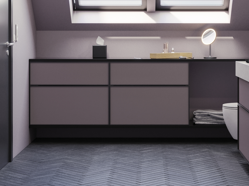 Baderom med skrå vegger inspirasjon, med baderomsmøbler i lilla med elegante rammefronter, flott oval speil med lampe, vakker og praktisk hylle, samt lilla malt vegg og grått fiskebeinsgulv som gir et elegant og moderne uttrykk.