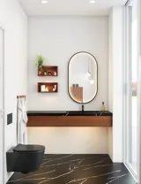 Moderne og stilfull baderomsinspirasjon med ovalt speil med svart ramme og lysstyring, farget toalett, servantskap, underskap og skap i rødbrun eik, Silestone servant og matchende gulv
