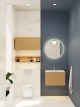Lite, stilfullt baderom med mørkeblå vegger, myke gule baderomsmøbler med riller, og elegant rundt speil med lampe