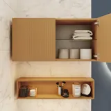 Lite stilfullt baderom med mørkeblå vegger, myke gule baderomsmøbler med riller, og elegant rundt speil med lampe