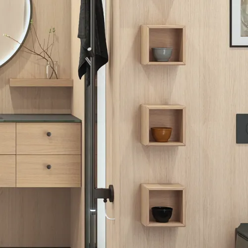 Stilfullt baderom i skandinavisk og japandi stil med lyse trevegger, rundt speil og minimalistiske baderomsmøbler