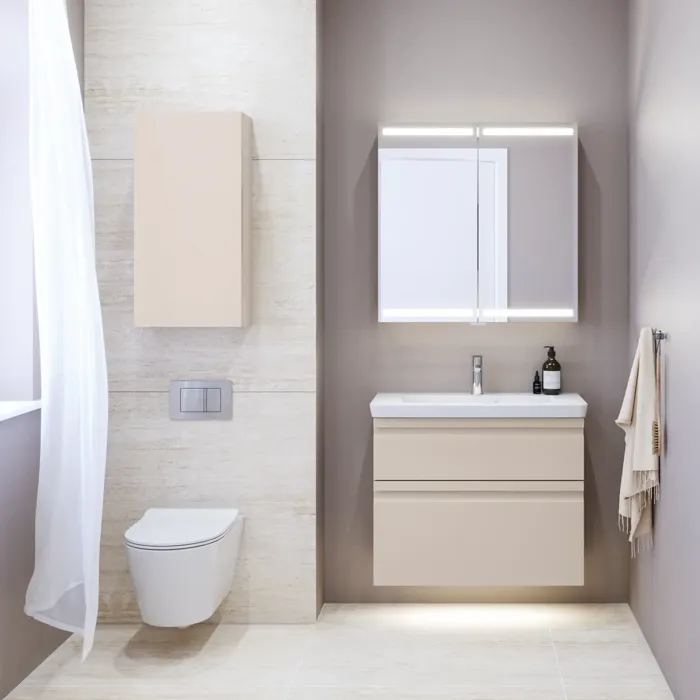 Liten baderomsinspirasjon med servantskap og overskap over toalett i beige spesialfarge, elegant speilskap med integrert lys, de lyse fargene og hvite gardinet skaper en romantisk og feminin atmosfære.