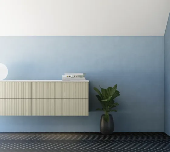 Baderom med skrått tak inspirasjon, beige baderomsmøbler med rifler, elegant benkeplate og firkantet bordstående servant, vakkert firkantet speil med stilige hyller, blå vegger, store vinduer og sort fiskebeinsgulv gir et lyst og urbant uttrykk.