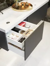Elegant og moderne baderomsinspirasjon med mørke marmorerte vegger, runde opplyste speil med svart ramme, vegghengt servantskap med dobbeltvask og en romslig dusjniche