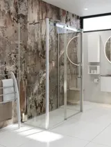 Baderomsinspirasjon med luksuriøst dusjkabinett med skyvedør, hvite baderomsmøbler og en rå vegg som gir badet en rå og urban følelse