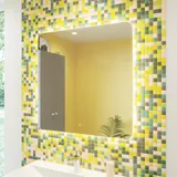 Baderomsinspirasjon med baderomsmøbler i matt grå med elegant servant, vakkert kvadratisk speil, grått gulv og små fliser i ulike nyanser av gult og grønt, som sammen med gul vegg gir et lyst og lekent uttrykk
