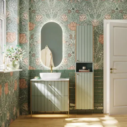Baderomsinspirasjon med baderomsmøbler i grønn spesialfarge med sider i naturlig eik, elegante riller, stilfull benkeplate med romantisk oval bordstående servant, vakkert ovalt speil, gir sammen med blomstrete tapet et yndefullt, vintage retro uttrykk.