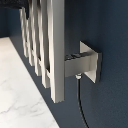 Elektrisk håndkletørker på mørkeblå vegg i stilfullt baderom.