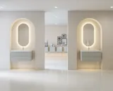 Stilfull og moderne baderomsinspirasjon med ovale speil med lysstyring, steinvasker og servantskap med fine og elegante riller i en minimalistisk design, badet har en lys og luftig atmosfære med elegant belysning og raffinerte detaljer.