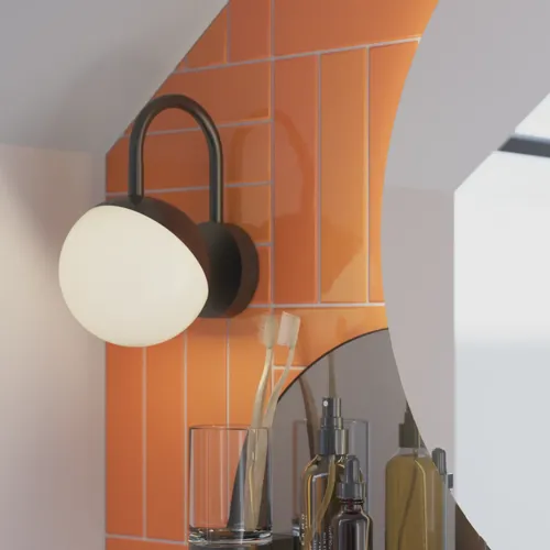 Bad med skråtak inspirert av et lite hvitt servantskap og høyskap med runde, svarte håndtak, samt et vakkert rundt speil og oransje fliser som gir et friskt og moderne uttrykk.