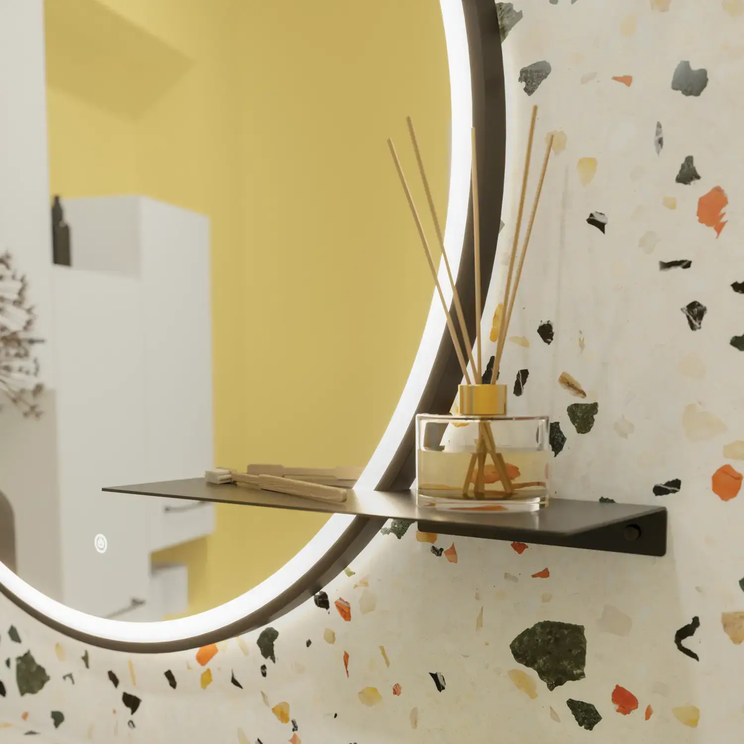 Liten baderomsinspirasjon med hvitt vaskeskap med svart grep og svart elegant vask, vakkert rundt speil med svart kant, forskjøvet plasserte overskap samt terrazzo vegg og gulv og gule vegger gir et modig og moderne uttrykk.