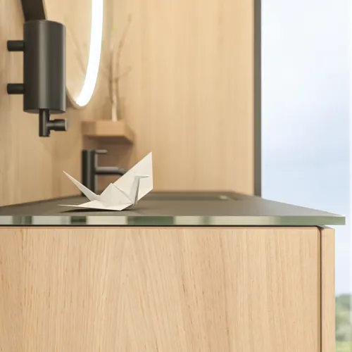 Stilfullt baderom i skandinavisk og japandi stil med lyse trevegger, rundt speil og minimalistiske baderomsmøbler.