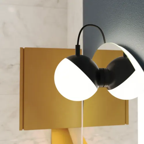 Lampe til speil med myke former på mørkeblå vegg i stilfullt baderom.